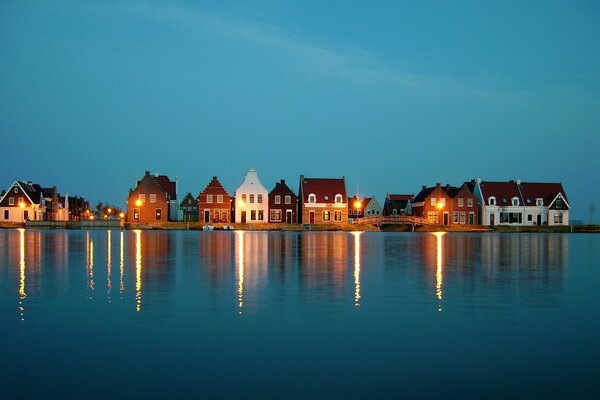 Small houses are reflected in the blue surface of the water