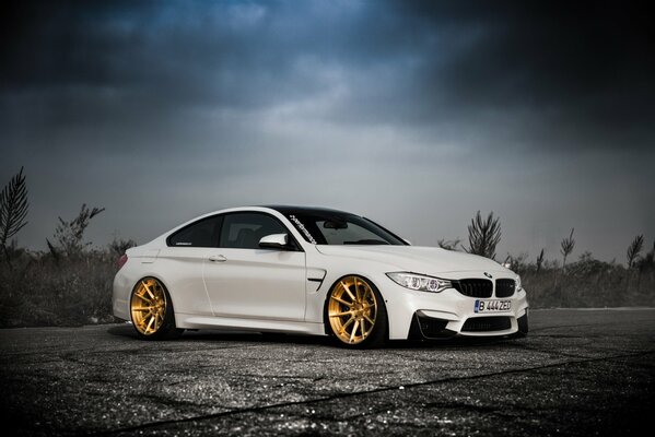 Blanc BMW dans la lumière de la nuit dans le brouillard