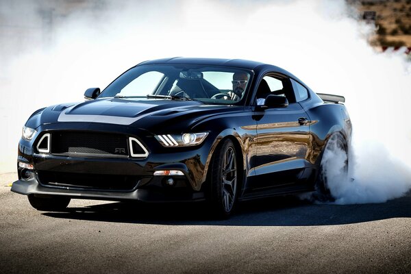 A metallic blue sports car leaves behind spectacular white smoke