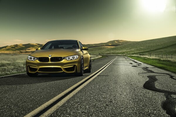 Bmw in motion on the road the color of gold