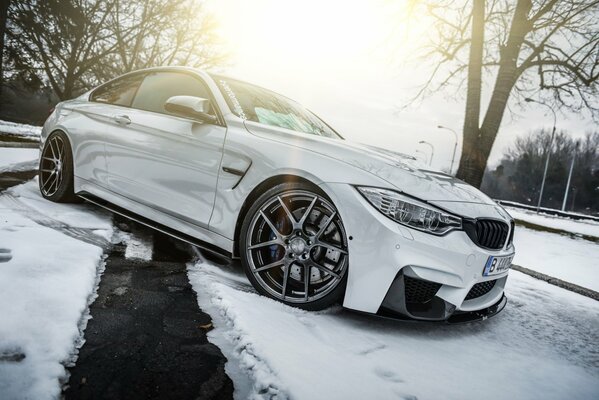 Une BMW blanche sur une route enneigée