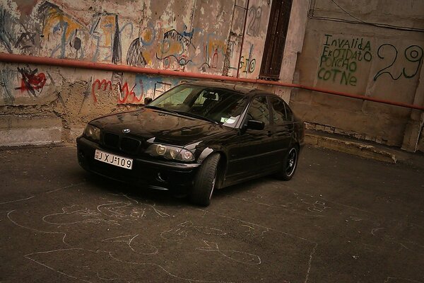 BMW e46 on the background of a wall with graffiti