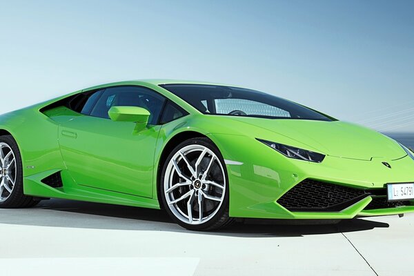 Ein Lamborghini in leuchtend grüner Farbe auf einem blauen Himmelshintergrund