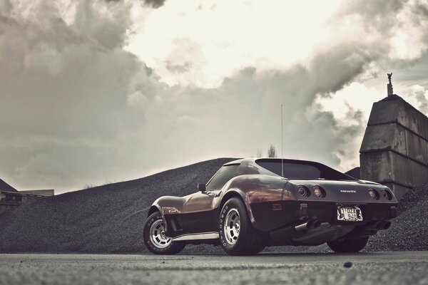 Black and white photo of the car. Cloudy sky