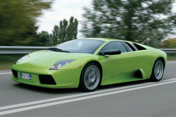 A green lamborghini is flying down the road