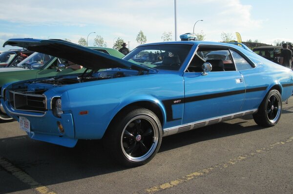 Voiture bleue avec capot ouvert et bande noire sur la carrosserie