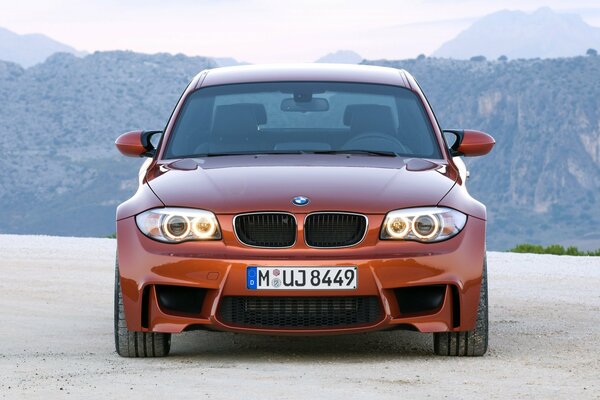 Cool bmw 1m brick-colored car on the background of mountains