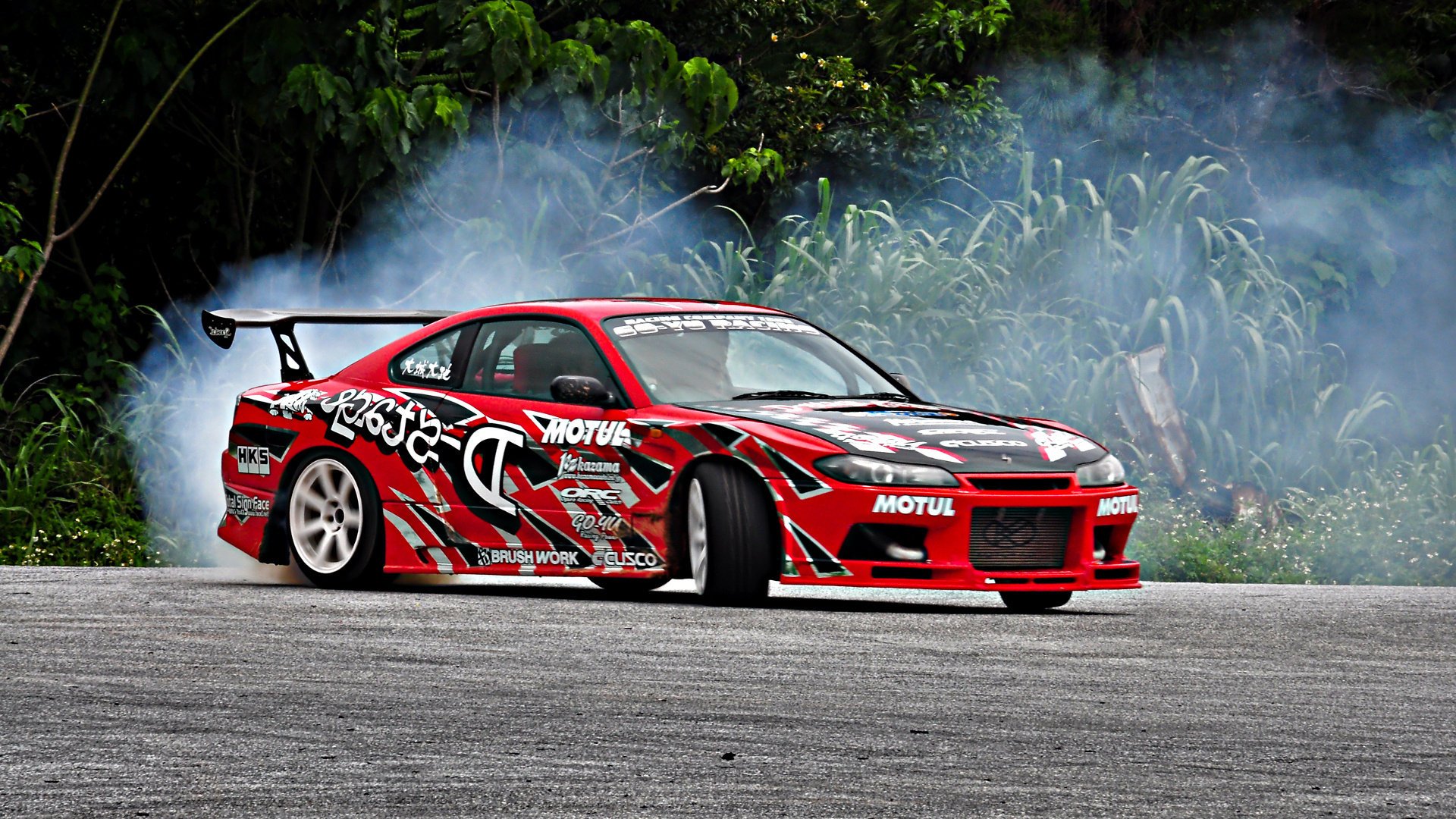 nissan drift smoke drift s15 drifting tuning silvia sports auto nissan inscriptions red car turn asphalt trees thickets bushes greenery sports cars transport cars motor transport