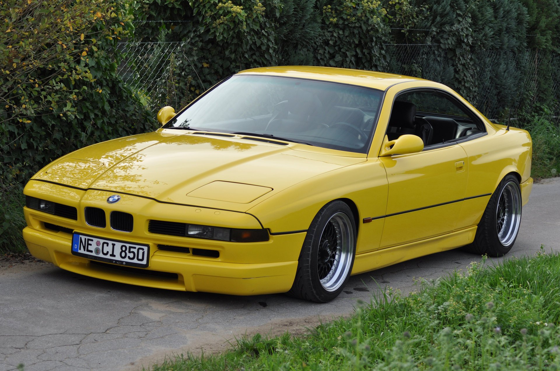 bmw 850 ci e31 bmw bmw coupe samochód sportowy żółty styl design hightech techno niemcy bawaria auto żółte auto samochód samochód transport trawa żywopłot zieleń liście samochody pojazd