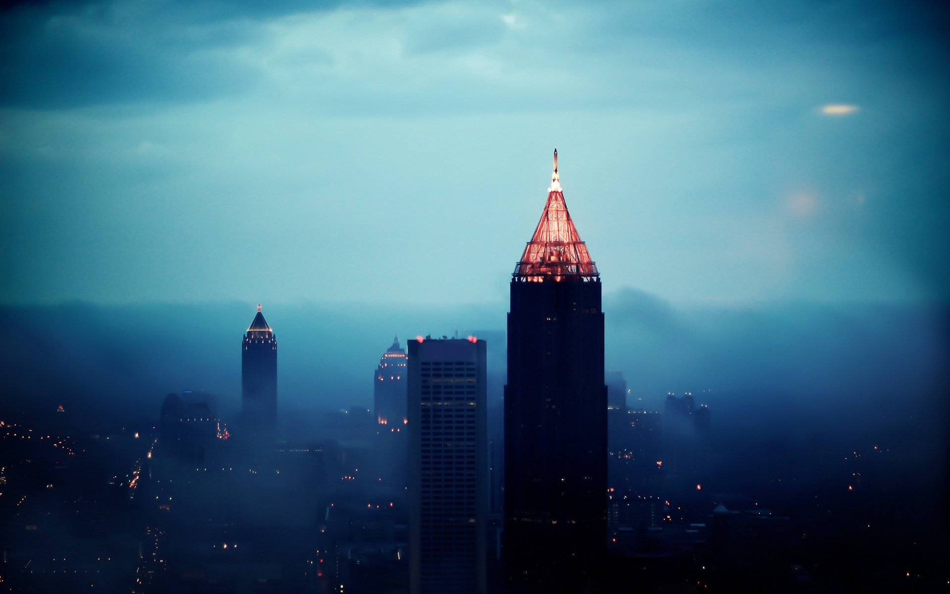 the city panorama skyscrapers the evening light lights height fog view megapolis home building clouds tower the lights of the city. smoke