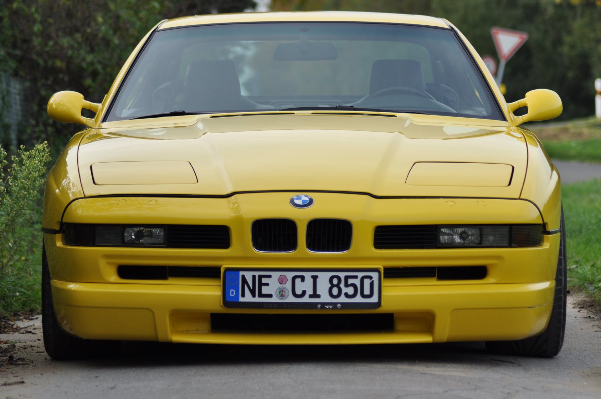 bmw 850 e31 bmw bmw coupé voiture de sport jaune style design high-tech techno allemagne bavière auto voiture jaune voiture véhicule transport herbe phares haie vue de face verdure feuillage voitures véhicules