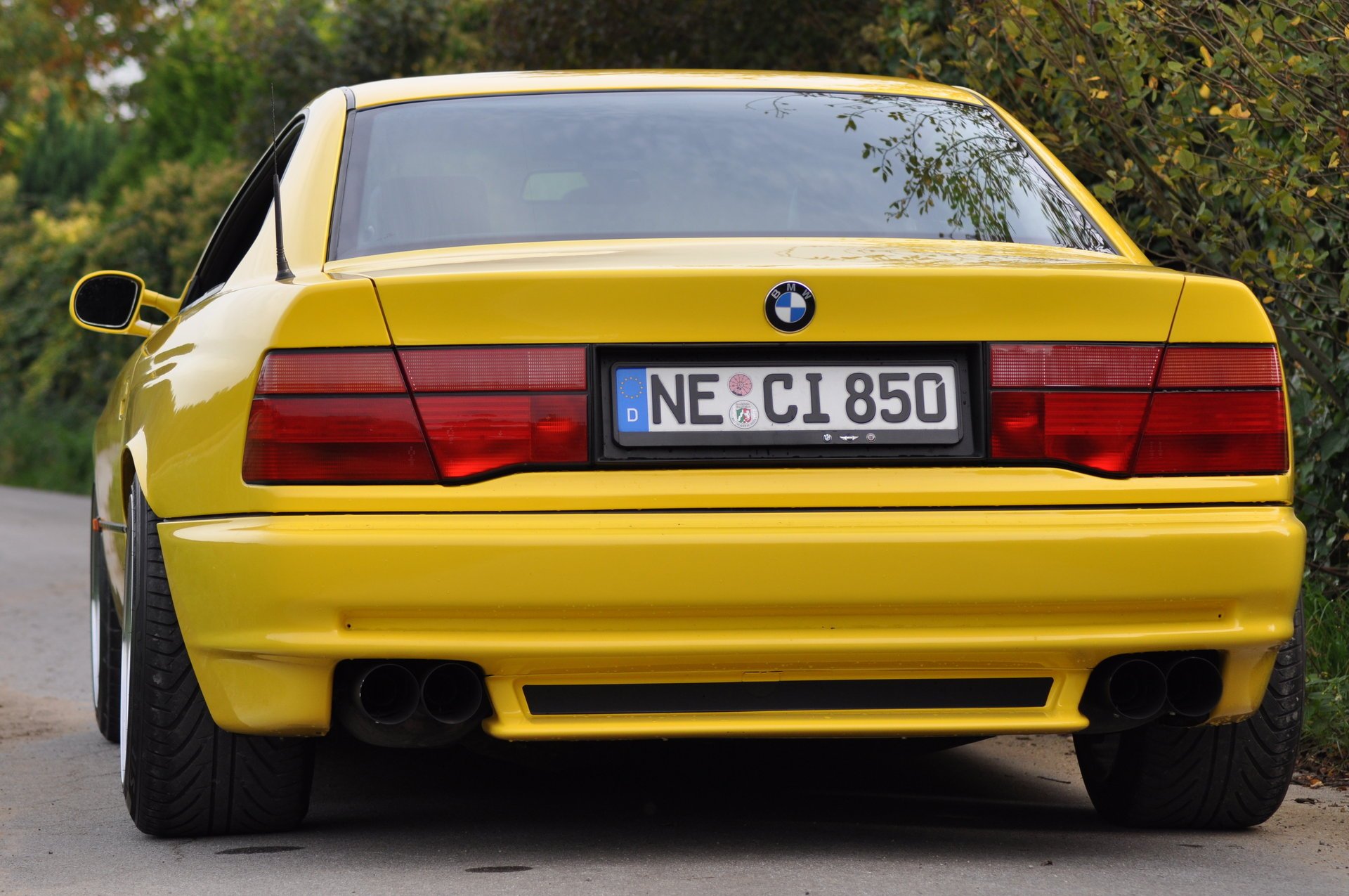 bmw 850 e31 bmw bmw coupé coche deportivo amarillo estilo diseño alta tecnología techno alemania baviera auto auto amarillo coche coche transporte hierba seto vegetación vista trasera follaje automóviles vehículos