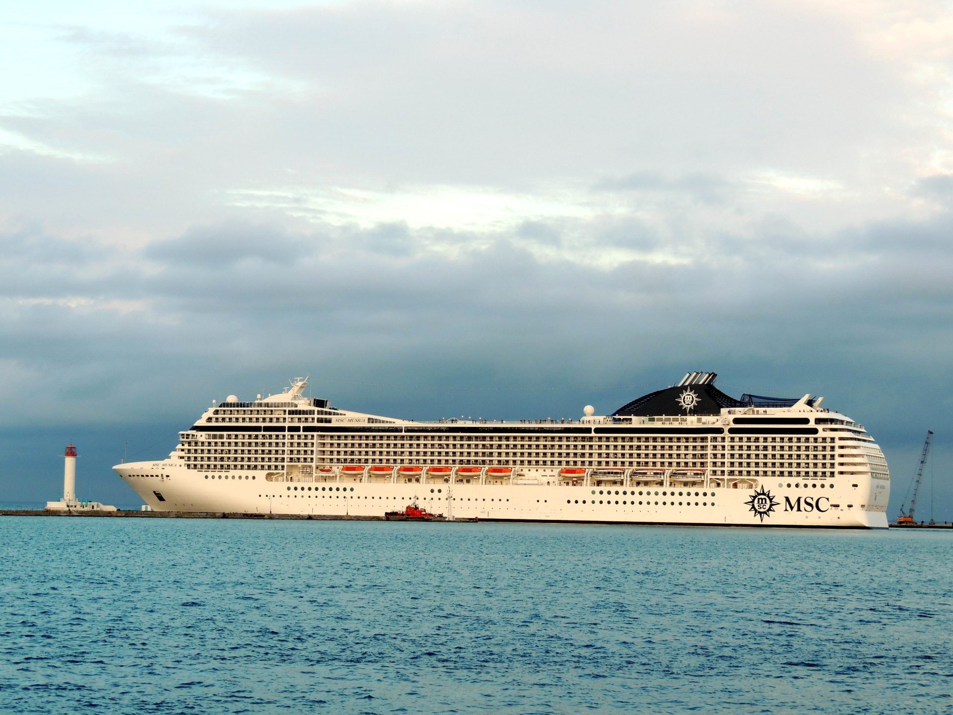 odessa port msc musica statek wycieczkowy holownik molo latarnia morska niebo chmury