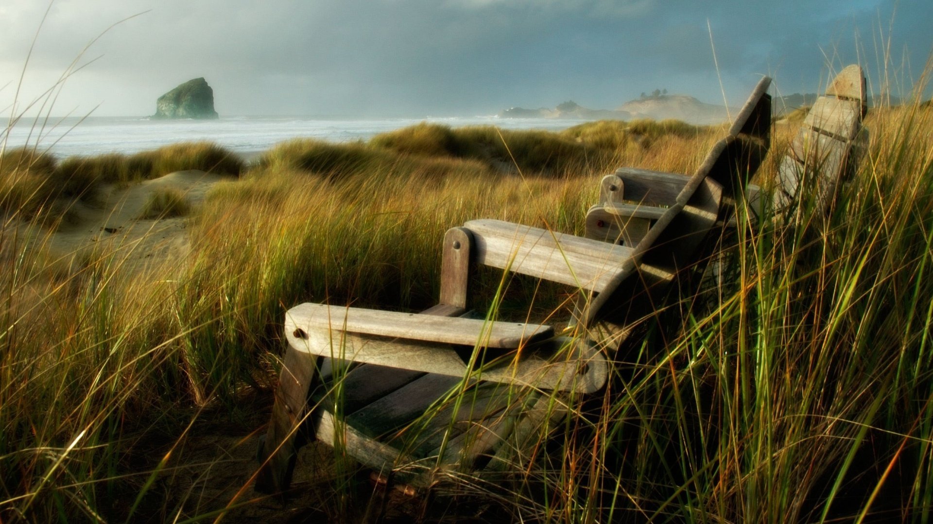 figure nic chairs grass field the wind shore coast rock stone sea overcast tall grass nature landscape