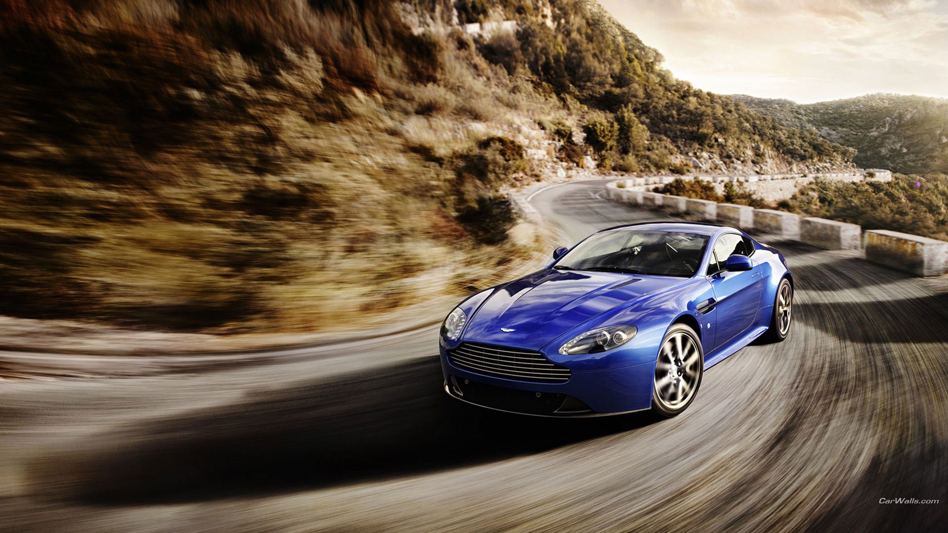 cook kate auto blue car speed movement turn mountains road car aston martin cars transport machine vehicle