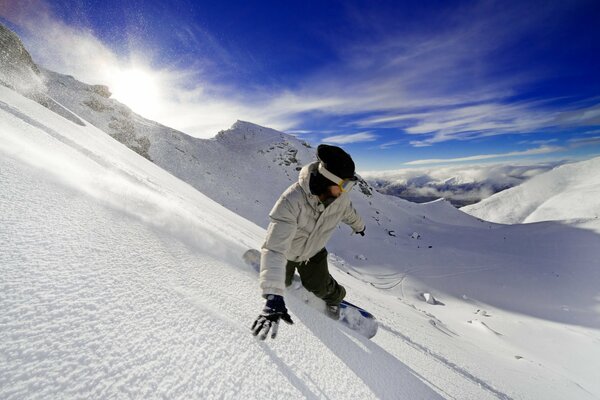 Un hombre se baja en una tabla de snowboard de una montaña