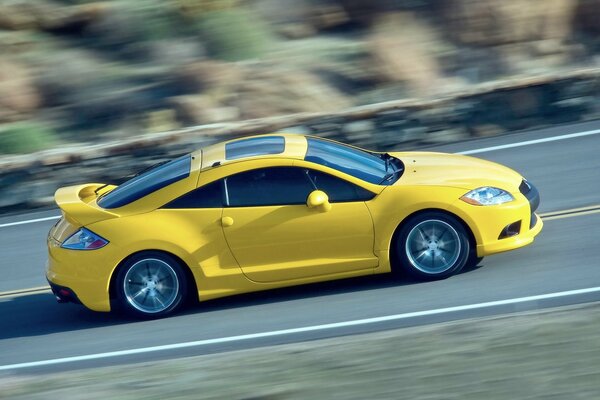 Voiture jaune vif vole dans la circulation sur la piste