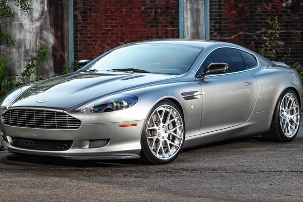 A beautiful silver car is standing at the gate