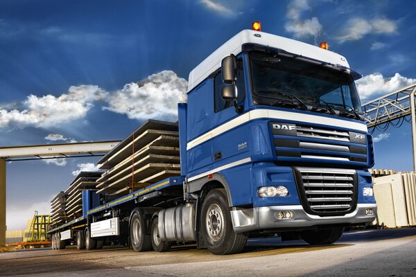 DAF bleu long avec une charge sur un fond de ciel bleu