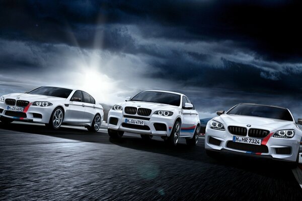 Tres blancos con rayas rojas BMW en la oscuridad