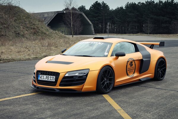 Ein leuchtend orange Rennwagen steht auf der Straße