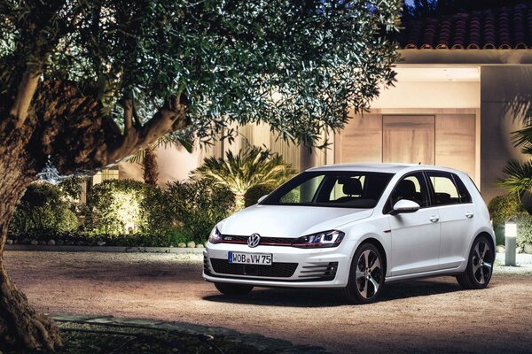 Volkswagen blanco en la casa a la luz de la noche