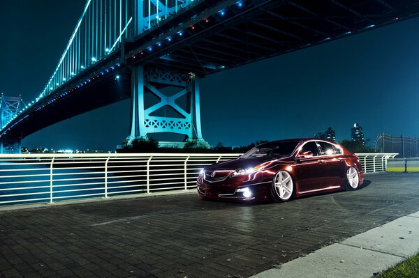 Honda de metal cerca del puente de la ciudad por la noche