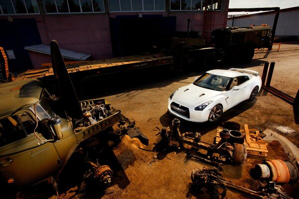 White car on the background of old spare parts