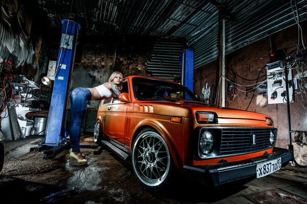 Fille et orange Niva dans le garage