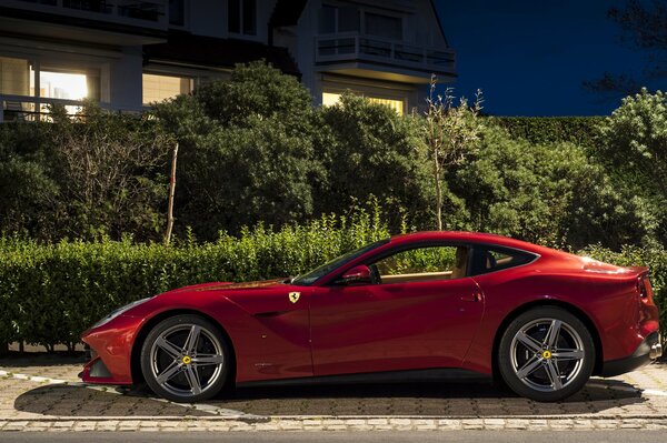 Red Ferrari Berlinetta near the mansion