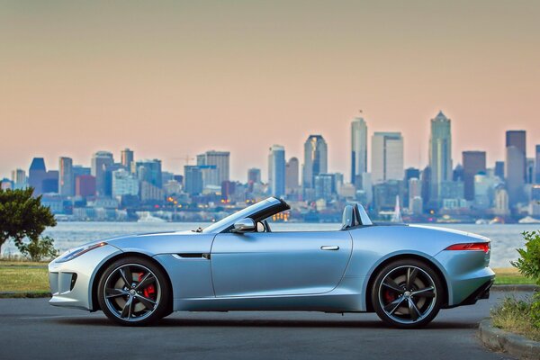 Jaguar car, city, skyscrapers, sunset, folding roof, river