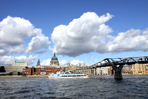 The boat goes along the Thames near the bridge