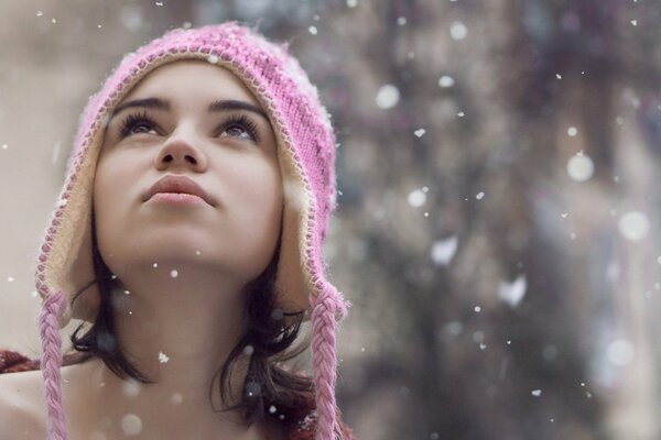 The surprised look of a model in a hat seeing snowflakes