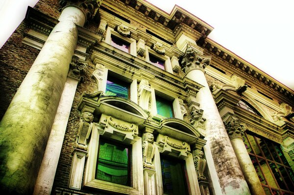 Fachada de una antigua casa con ventanas verdes