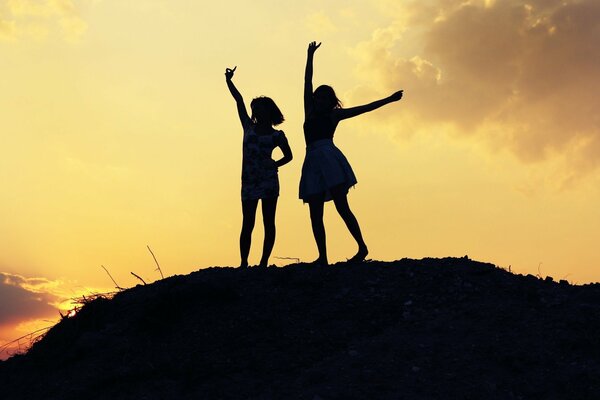 Silhouettes of two girls at sunset