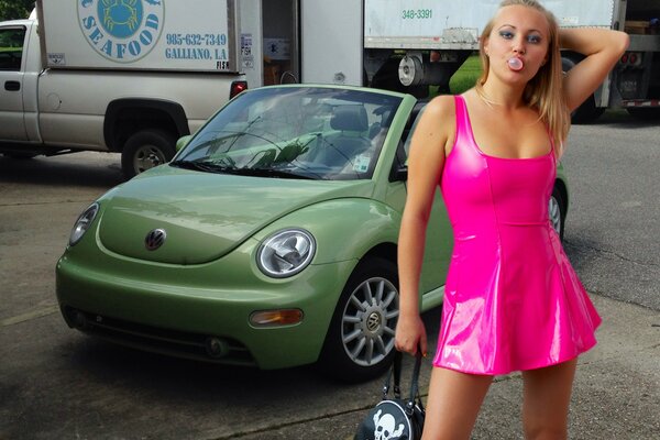 Blonde girl near green volkswagen beetle