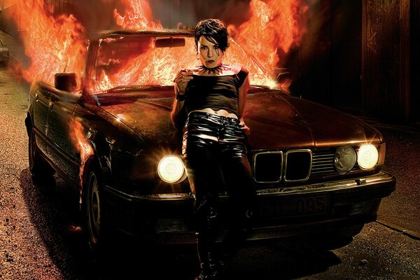 A girl on the background of a burning car