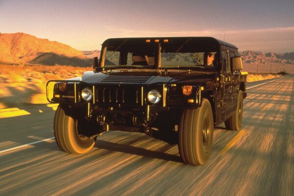 Negro SUV Hummer en la carretera en el desierto