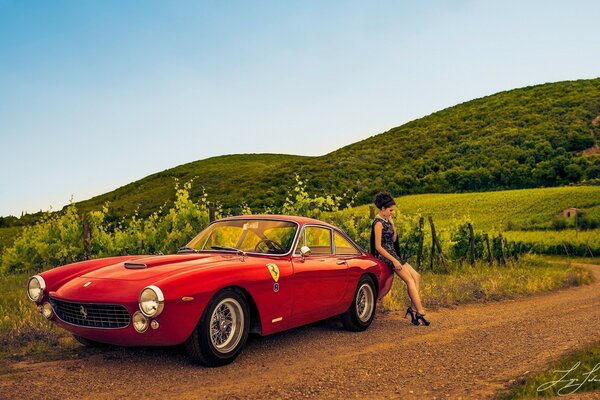 A girl in nature near a red car