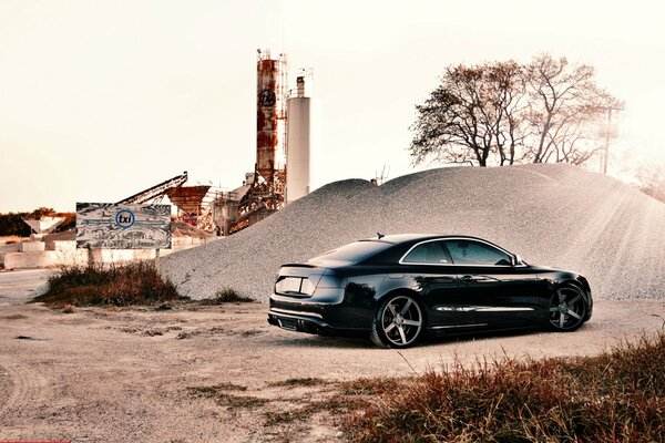 Voiture audi s5 sur fond de paysage industriel