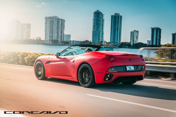 Coche convertible rojo Ferrari monta en la carretera