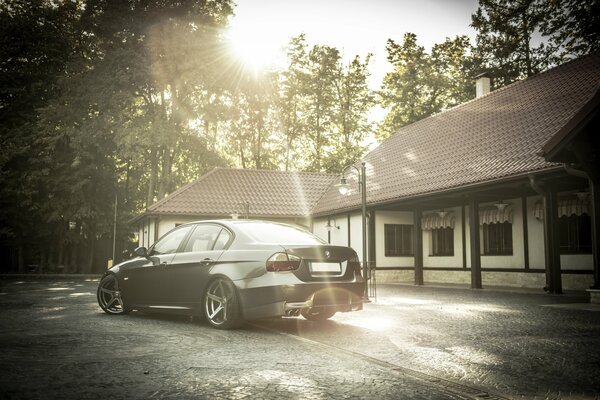 BMW e90 car on the background of a one-story house with an attic