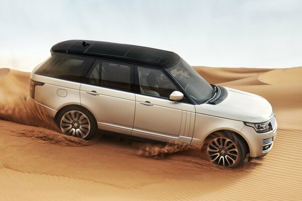 Foto eines Range Rover-Autos auf dem Sand in der Wüste