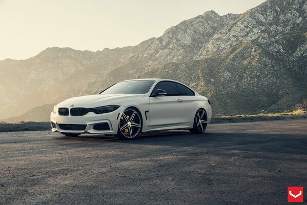 White bmw car on the background of mountains and dawn