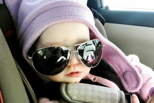 Petit enfant dans la voiture avec des lunettes