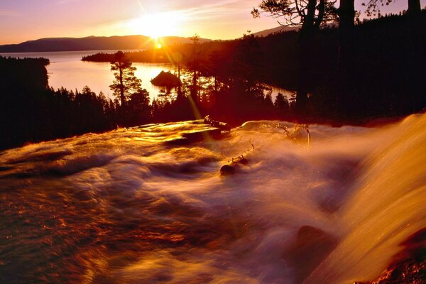 Les éclaboussures de cascade reflètent les rayons du soleil