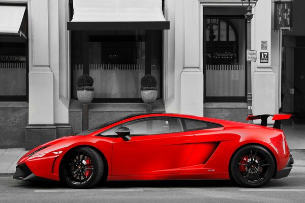 Lamborghini rojo jugoso entre la ciudad