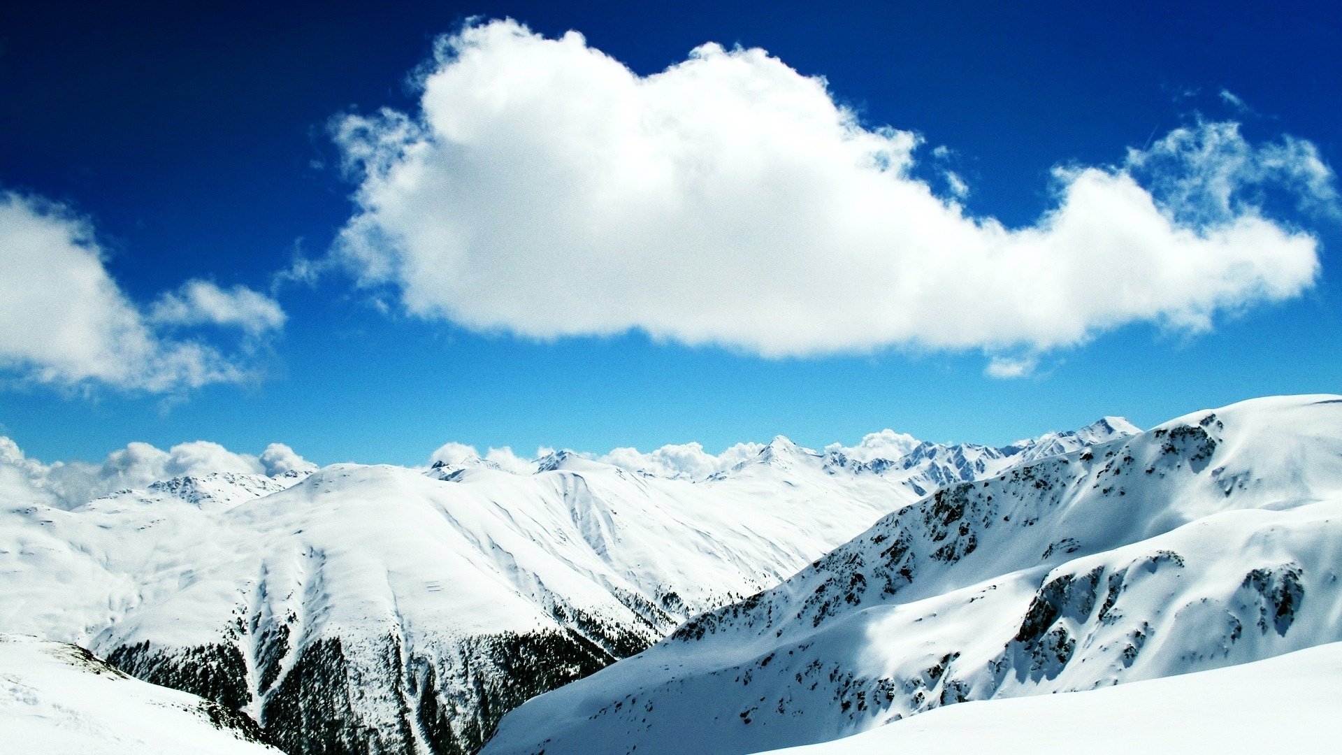 high in the mountains snow carpets clouds mountains the sky winter nature landscape height the snow tops frost blue