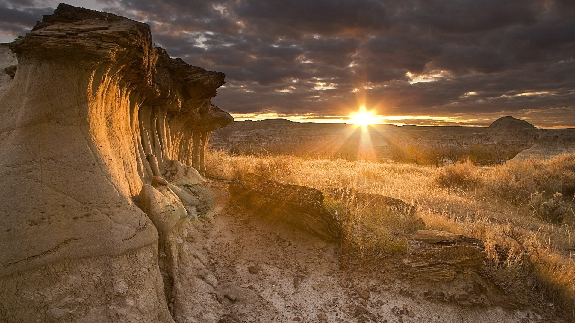 ein stern namens sonne sandgestein der berge trockenes gras sonnenuntergang landschaft wolken