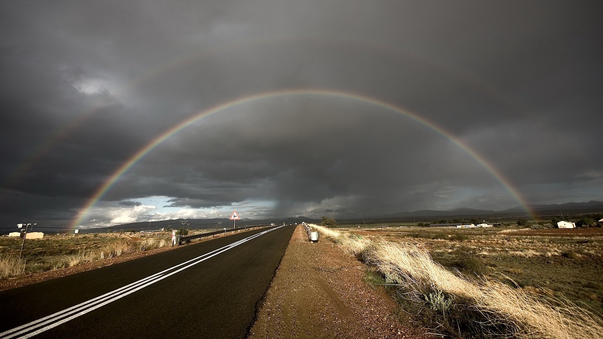 the track in the future feather the storm rainbow road markup index road sign field clouds bad weather